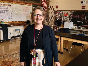 woman standing in classroom smiling at camera